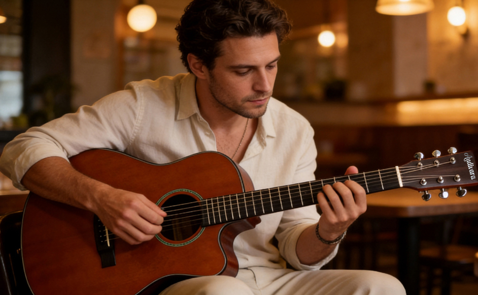 Man playing Audivara 41 inch vintage stained acoustic guitar in a cozy cafe