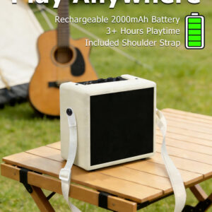 Rechargeable battery powered mini guitar amplifier with shoulder strap on an outdoor table